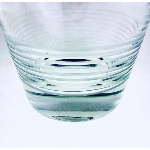 This wine bucket is blown leaded glass with cut and polished decorative lines at its base. The rim is polished....