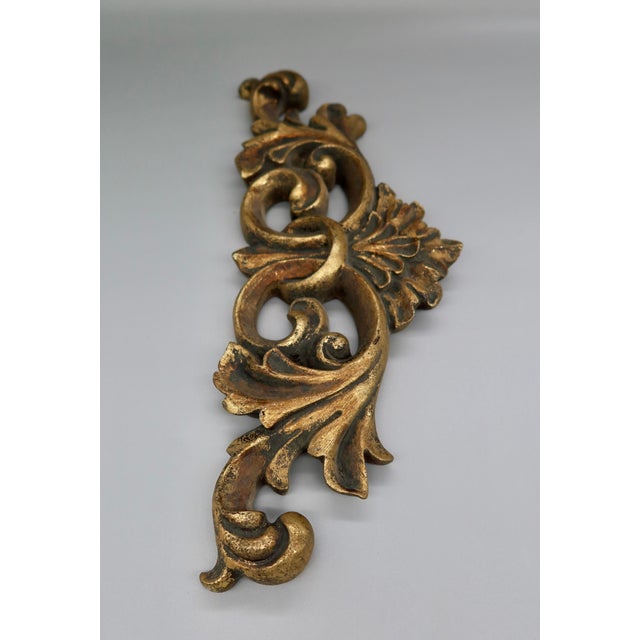 A substantial horizontal gilt scroll swag, cast in resin with deep, sculptural acanthus leaf and scrollwork relief...