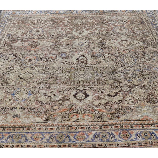 This distressed antique Persian Mahal displays geometric flowers and an all over design in earth tones. Keivan Woven Arts...