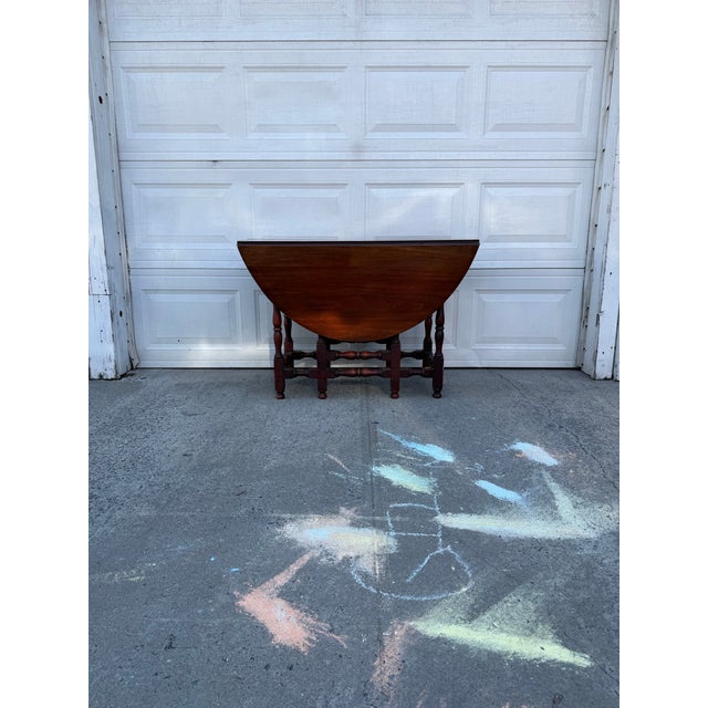 We have an absolutely stunning vintage mahogany gateleg dining table for sale. It features a classic Colonial Revival...