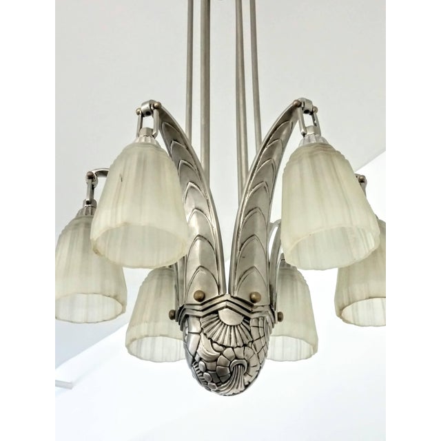 A stunning French Art Deco chandelier with a half dome flower geometric motif centerpiece supporting six stylized...
