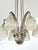 A stunning French Art Deco chandelier with a half dome flower geometric motif centerpiece supporting six stylized...