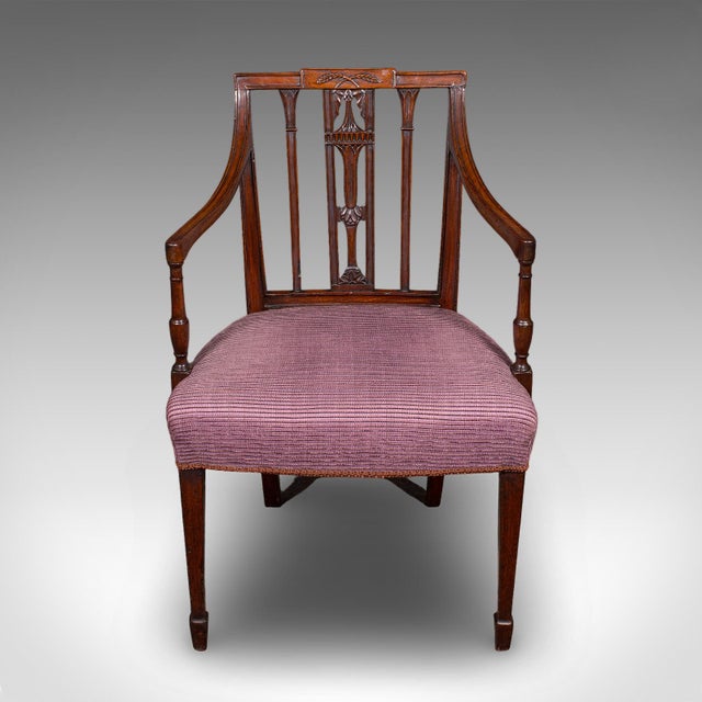 This is an antique morning room chair. An English, mahogany desk or elbow seat in Sheraton taste, dating to the Georgian...