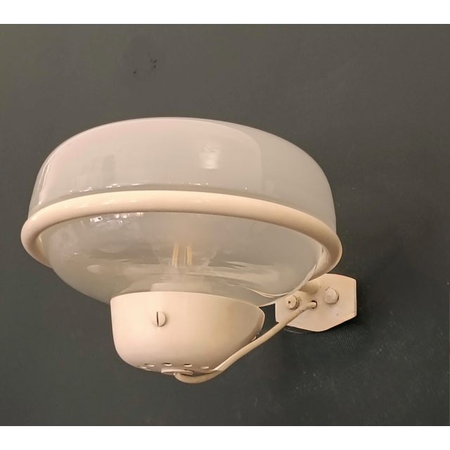 Wall lamp Mod. 228 designed by Gino Sarfatti for Arteluce in the 1950s. The lamp is made entirely of opal glass with a...