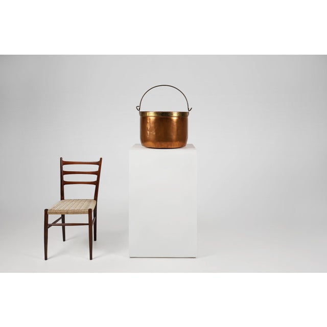 Large red copper kettle or bucket crafted in France around 1850. Hammered copper log kettle with a brass rim to the top...
