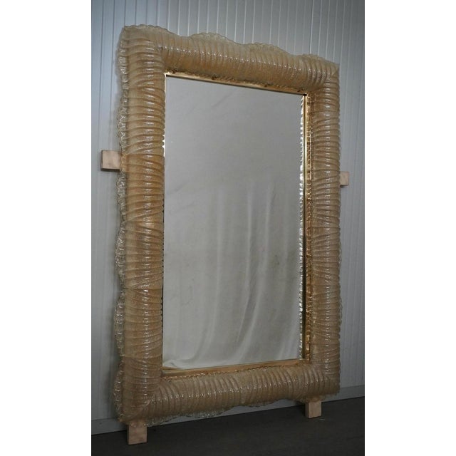 A sturdy gold-colored frame captures the eye of the observer, leaving him enchanted: it is a wall mirror in gold-colored...