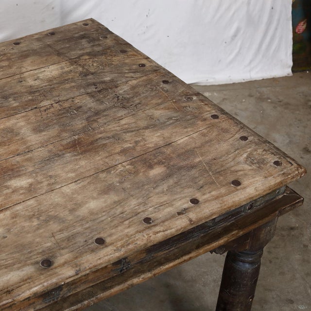 Antique Teakwood Dining Table, in its pure untouched state, with baluster legs, carved apron brackets and a nail head top....