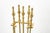 A brass five piece tool fireplace set with a rectangular footed base with an arched brass carrying loop and a brass...