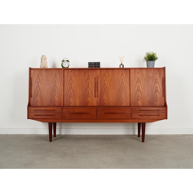 The highboard was made in the 1960s, Danish production. The structure is covered with teak veneer. The legs are made of...