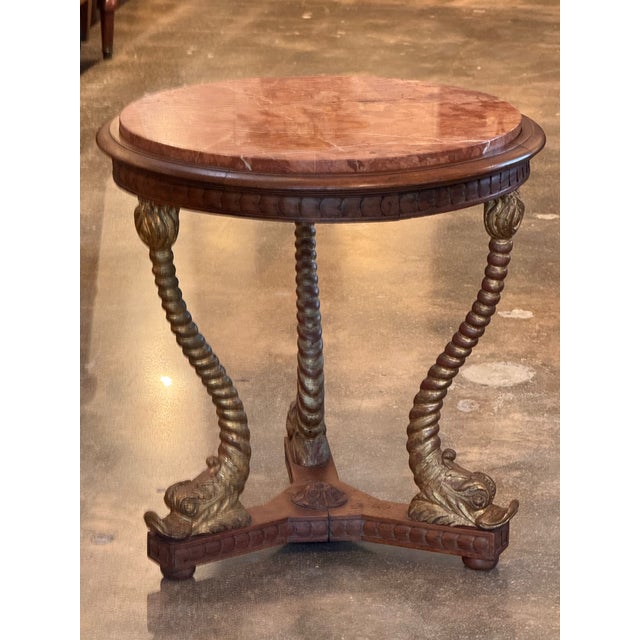 This table has so much style. It has a gilded dolphin base and a marble top.