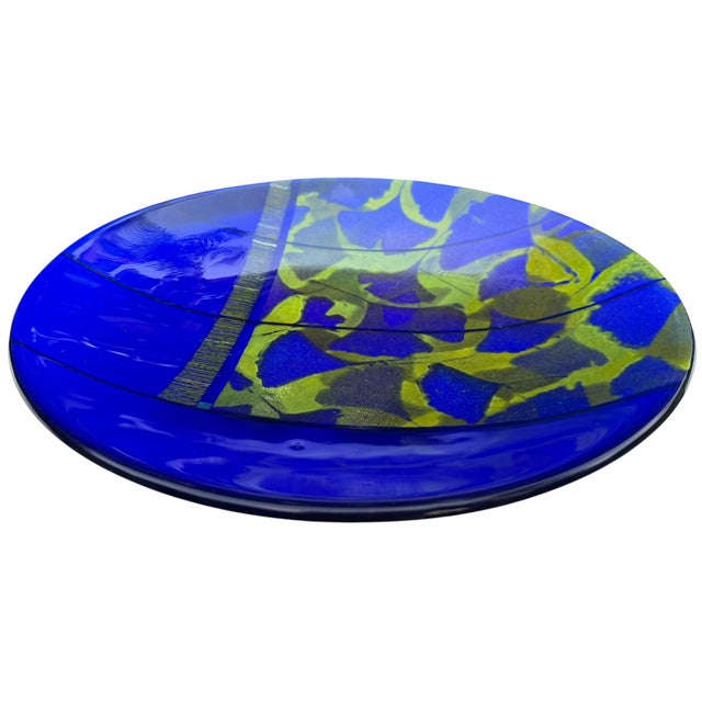 Signed studio art glass charger plate by Richard Ritter, dated 2005. Executed in layered cobalt blue glass with abstract...