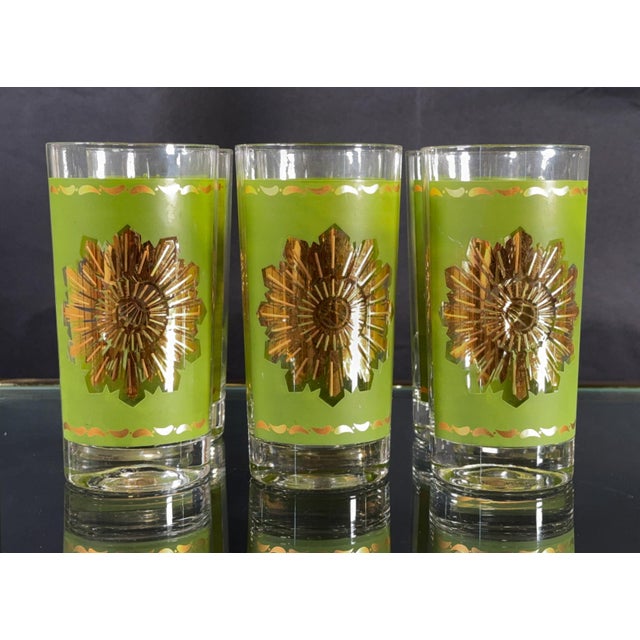 This set of six highball glasses carries a bold avocado green enamel band with a gold starburst medallion and orange wave...