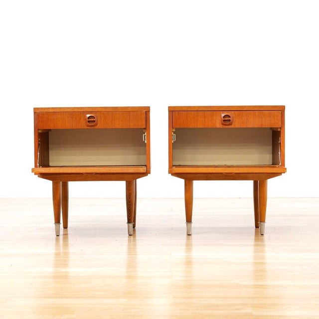 Pair of mid century nightstands produced in Denmark during the 1970s.&nbsp; A nice minimalist set, in warm teak that sit...