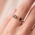 A bold, contemporary open-cuff ring featuring two earthy smoky-brown quartz stones — an oval-cut stone paired with a...