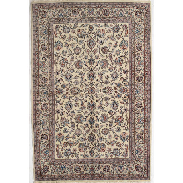 Antique hand-knotted Persian Mashad wool rug with an ivory field featuring an allover floral pattern of scrolling vines...