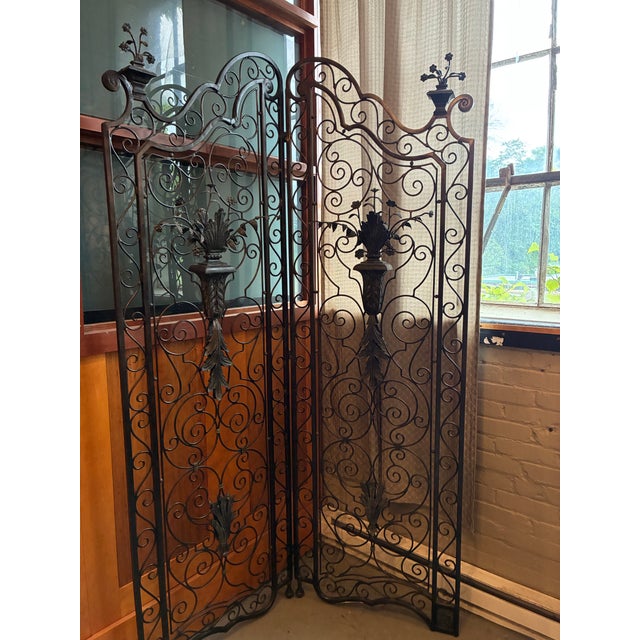 Each panel measures 26” wide x 5” deep x 82“ height at center. Wrought Iron two part folding screen shows elaborate...