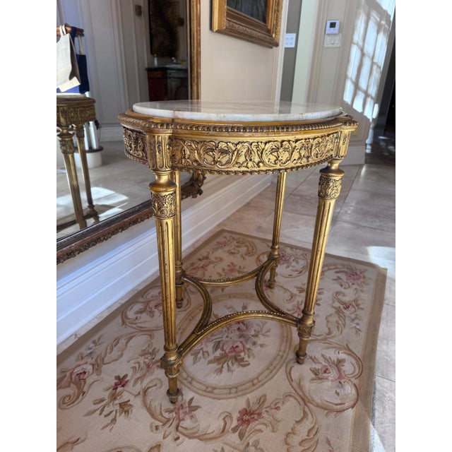 A French Louis XVI–style oval guéridon in carved giltwood with an inset onyx-marble top. Late 19th century. The oval stone...