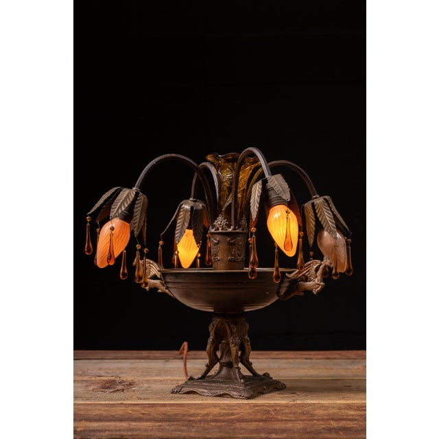 Cast metal boudoir table lamp designed in the Art Nouveau taste with four gracefully arched arms supporting pink slag...