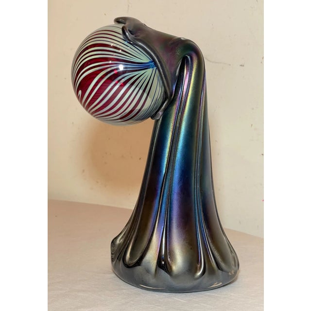 This exquisite glass sculptural vase is a stunning piece of art crafted by HAT. The rainbow hues of the iridescent glass...