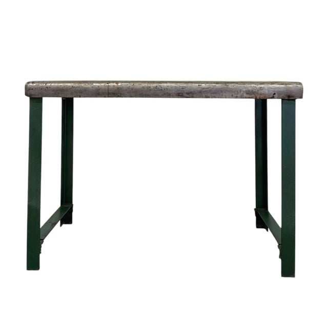 Built to withstand heavy-duty use, this industrial metal table features a raw steel tabletop with an authentic, naturally...