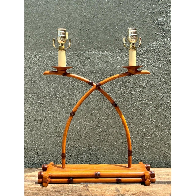 This vintage double arm lamp is crafted from metal finished to convincingly resemble faux bamboo, blending an organic...