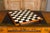 An English satinwood desk and game table from the 19th century with tilt top writing area, checkerboard and two drawers....