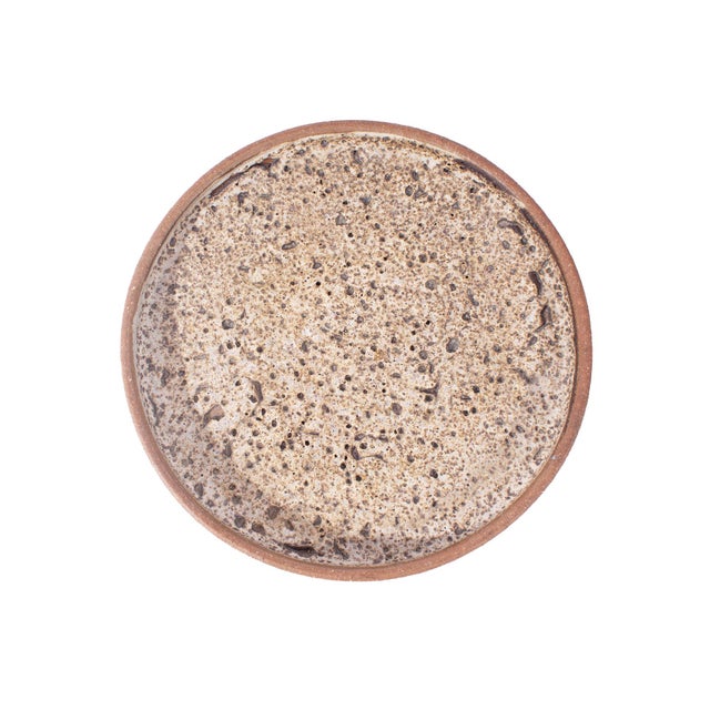 A studio pottery charger by the American artist Edna Arnow (1921-2013). Signed to the underside, the charger has a...