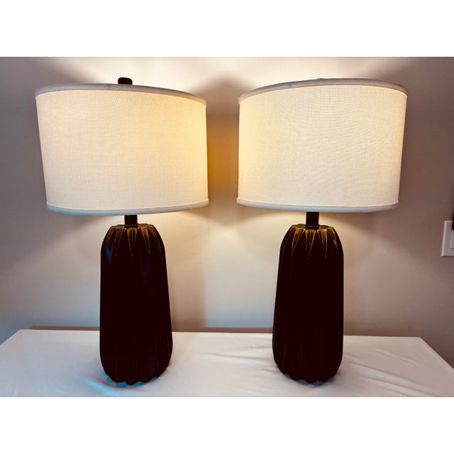 Pair of vintage high-end wooden table lamps with a sculptural, modern design. Each lamp features a rich dark wood with...