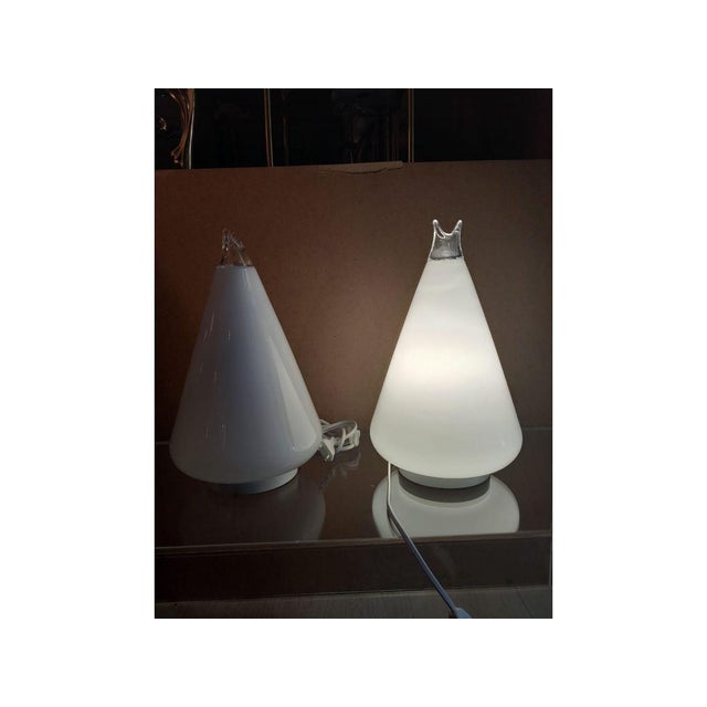 This artwork features two contemporary lamps, embodying a minimalist and futuristic aesthetic. Each lamp adopts an elegant...