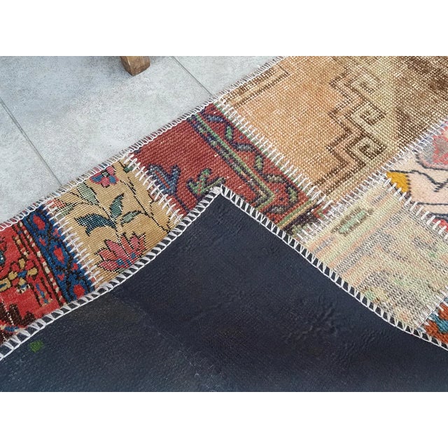 This is a vintage Turkish Oushak rug from the Mid 20th Century. The piece was hand-knotted.