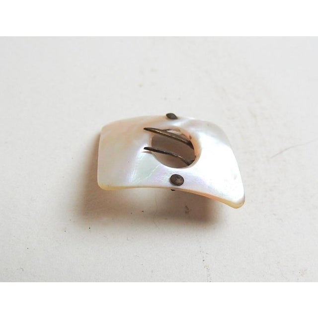 Small antique late 19th century mother of pearl pin or brooch with brass accents in the shape of a buckle. Old stock never...