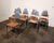 Chic, cast aluminum postmodern industrial dining chairs with warm cherry wood seats designed by Los Angeles designer and...