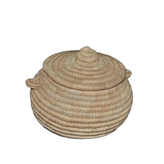 A smooth coiled basket with rounded lines handwoven in the 1970s, in Cairo Egypt by traditional artisans who kept the...