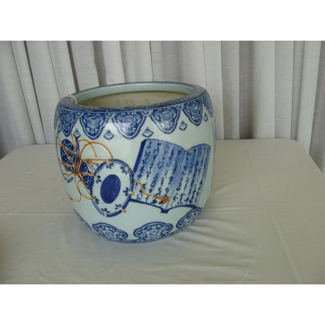 Asian jardinier with overall decoration of books and tables with gold incised rope decoration. with wood base. Inside...