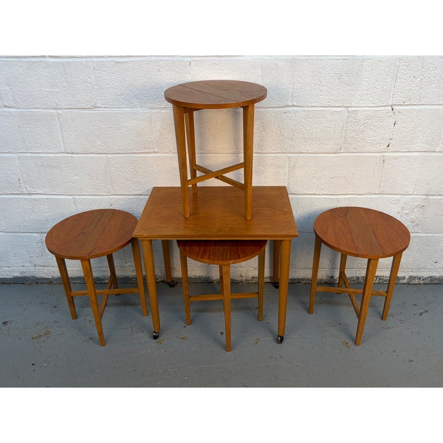 A striking set of mid-century modern teak nesting tables, attributed to Danish designer Poul Hundevad and dating to the...