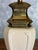 An American Stiffel table lamp from the 1950s, featuring a cream-colored ceramic body mounted on a stepped brass base. Its...