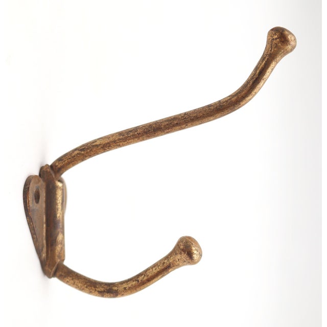 Vintage steel double arm wall hook with a brass finish. The original mounting screws are not available. Good condition...