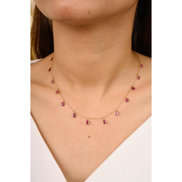 This is part of Chairish’s Fine Jewelry assortment. Pear Bezel Set Ruby Fringe Necklace in 18K Gold studded with pear cut...