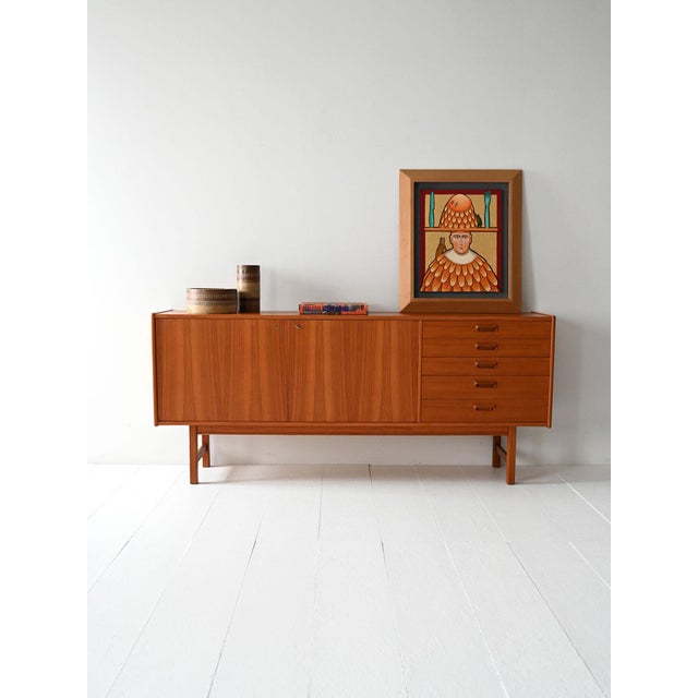 Vintage teak sideboard with hinged doors, side drawers, and the original cutlery tray. Scandinavian teak sideboard from...