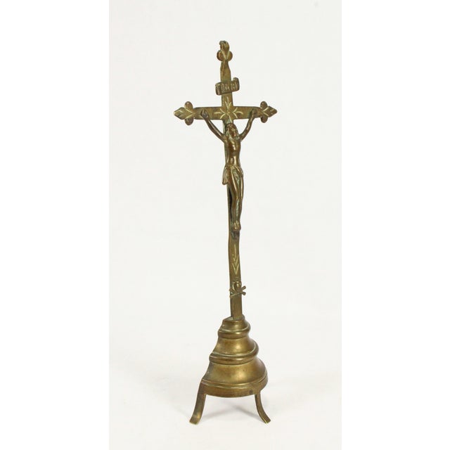An early standing brass crucifix The Corpus Christi figure is cast with good detail It is raised on a tripod pedestal,...