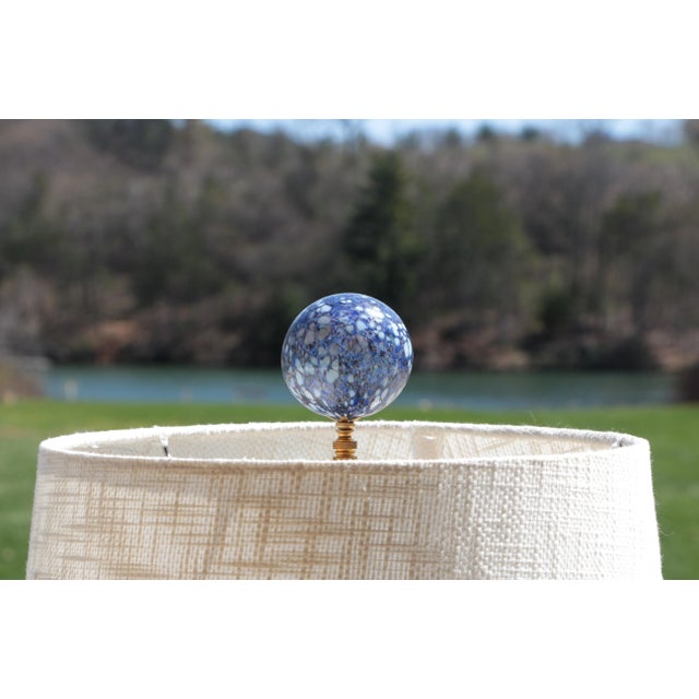 Single lamp finial crafted from a large, speckled blown glass bubble topping a knurled brass swivel base. Shown/modeled on...