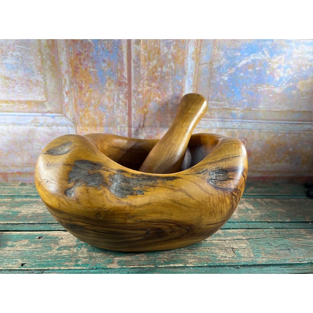 Carved from a single monumental block of olive wood, this large mortar and pestle is both a functional object and a...