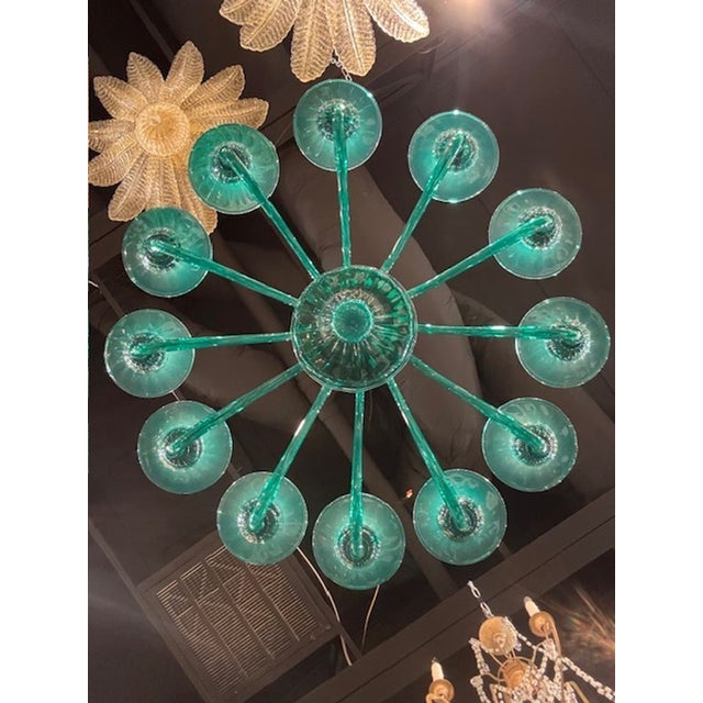 The Teal 12 Arm Murano Glass Chandelier is a stunning modern lighting fixture. Made from high-quality Murano glass, this...