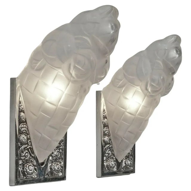 A pair of French Art Deco wall sconces by the French artist "Degue" is in great condition. Shades are in clear frosted...