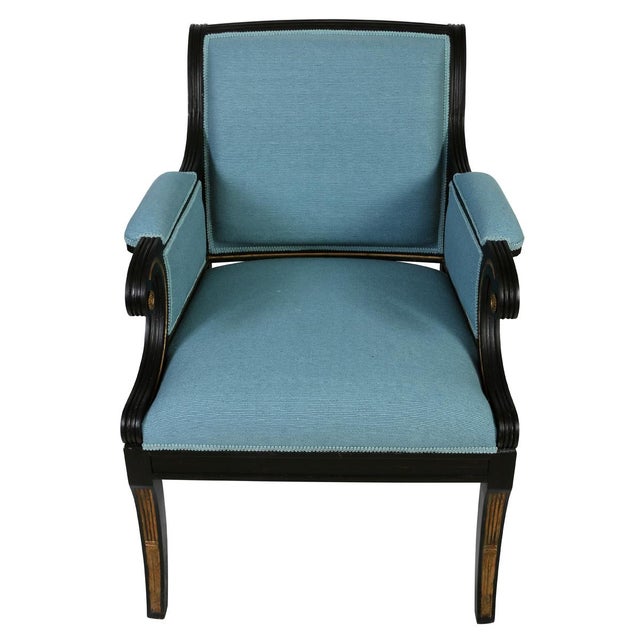 A pair of Julian Chichester regency style arm chairs newly upholstered in raw blue silk. The ebonized frames are accented...