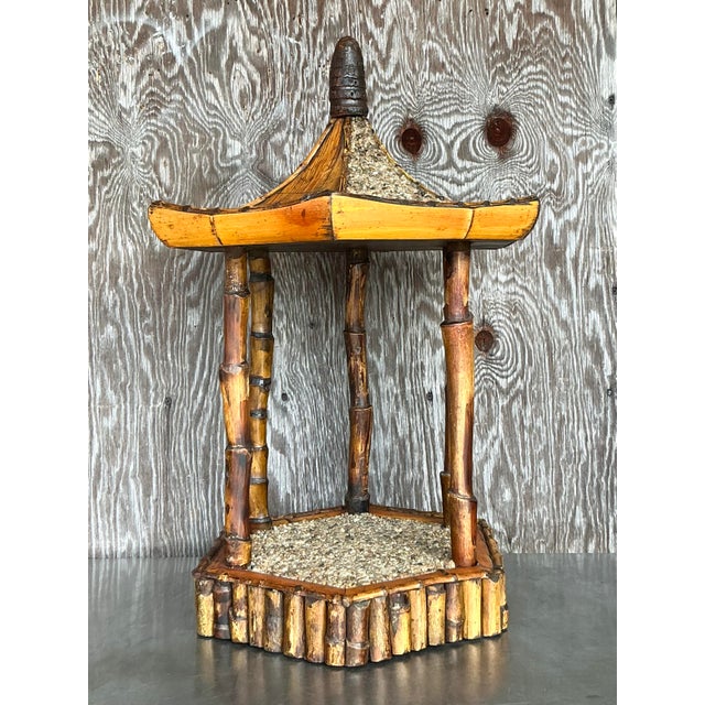 This exquisite vintage coastal rattan pagoda pedestal showcases a beautifully handcrafted design, featuring a charming...