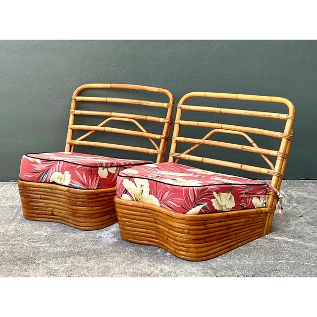 This pair of vintage slipper chairs shows the sculptural stacked rattan construction associated with Paul Frankl. Each...