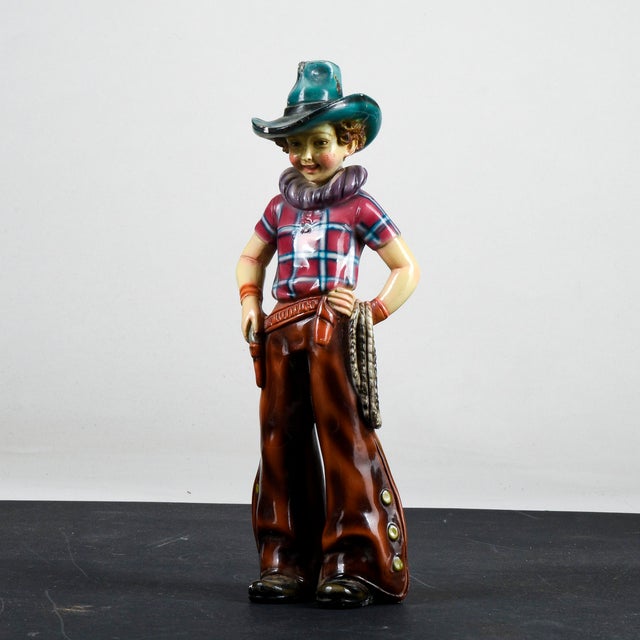 This polychrome plaster sculpture, depicting a cowboy, is an example of artistic production from the 1960s. Branded ILPA...