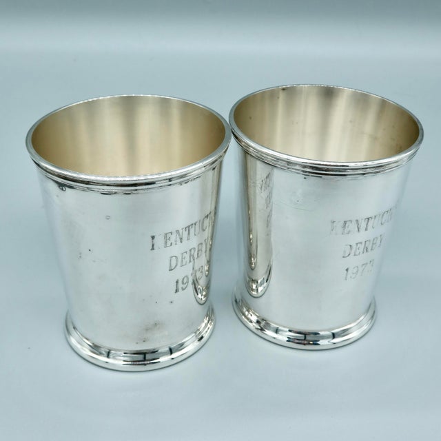 Pair of silverplate mint julep cups engraved “KENTUCKY DERBY 1973” on the exterior, with maker’s mark on the underside....