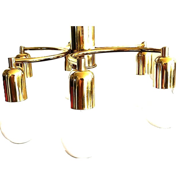 Elegant german six-light flush mount ceiling lamp from the 1970s, crafted in polished brass-finished metal. Its gracefully...
